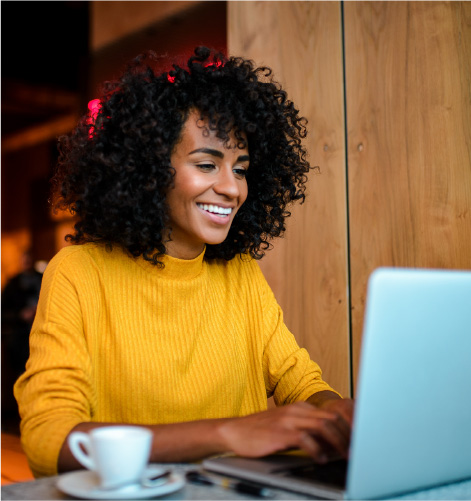 Woman smiling and looking at a laptop.