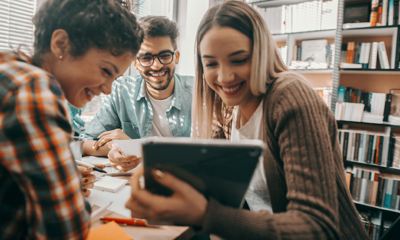 Small group of college students looking at a tablet.