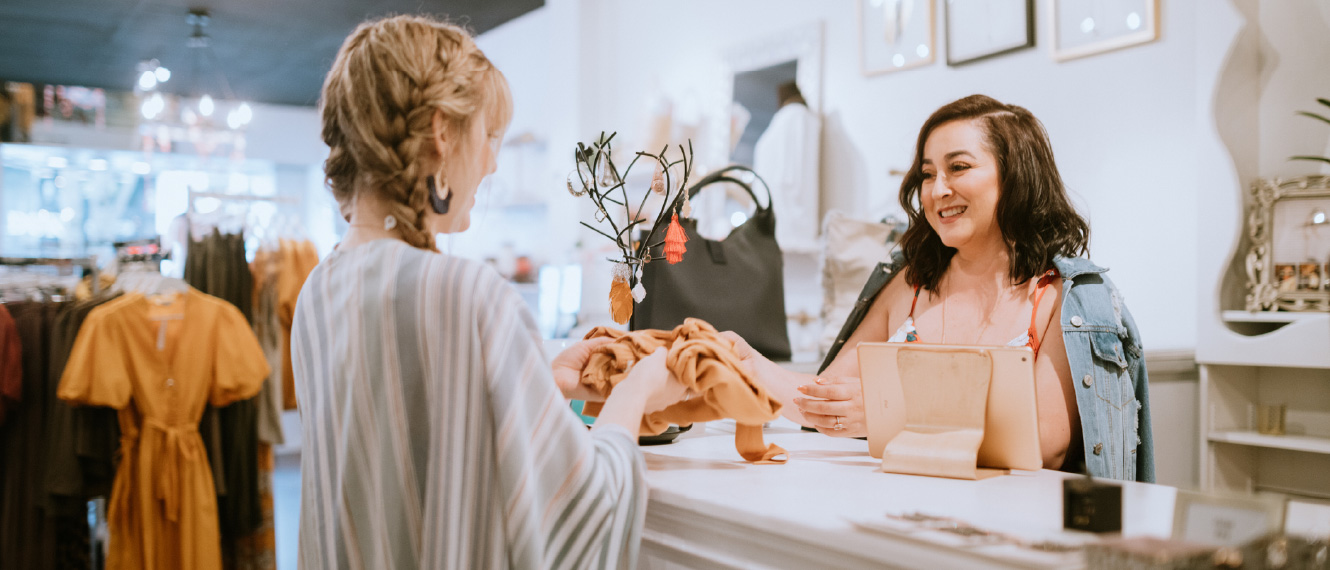 Young woman at a counter in a clothing shop.